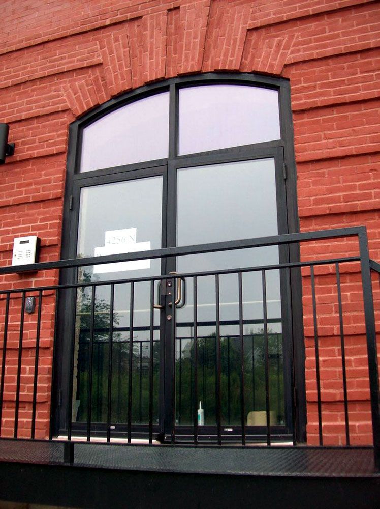 A brick building with a balcony and a large window