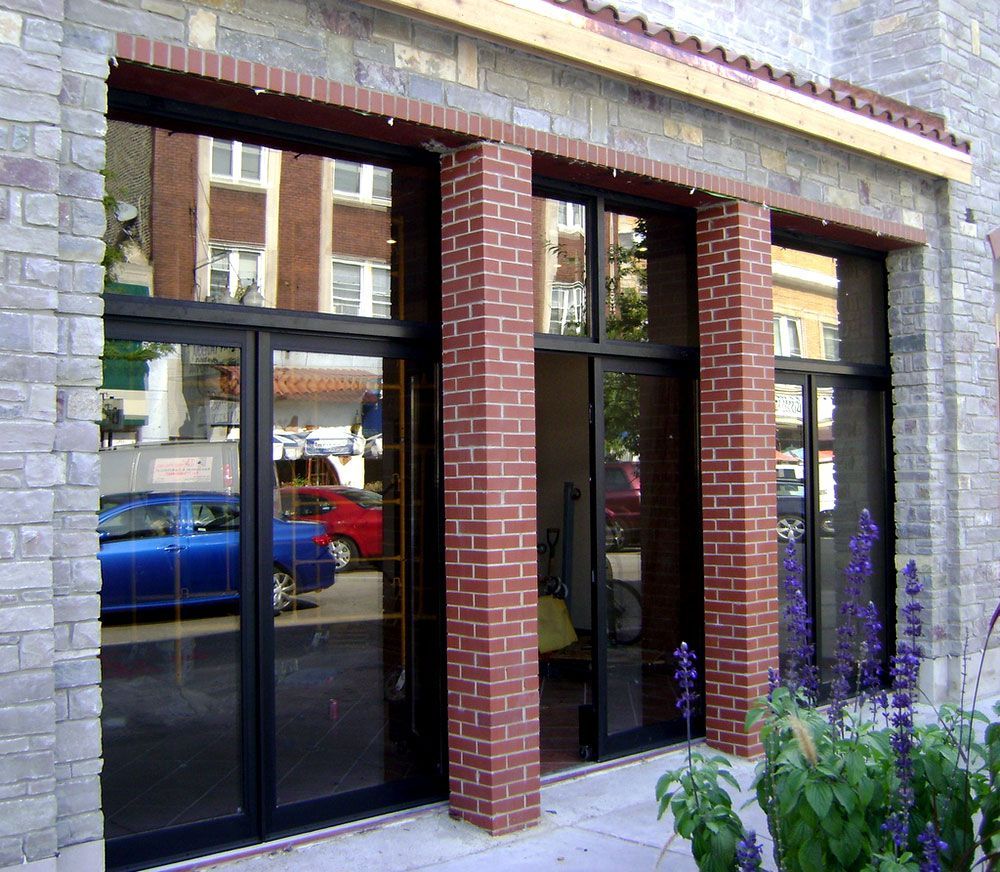 A brick building with a blue car parked in front of it