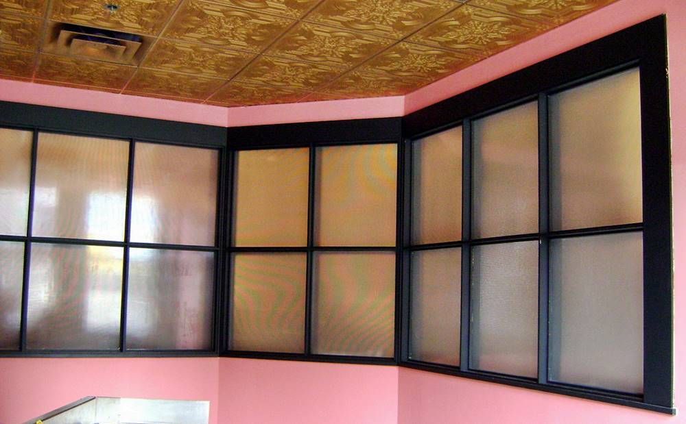 A room with pink walls and black windows