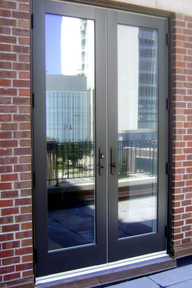 A brick building with a sliding glass door leading to a balcony