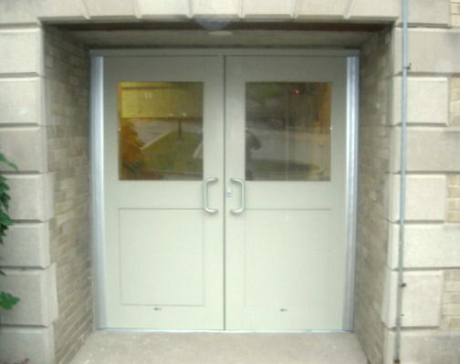 A white door with a brick wall behind it