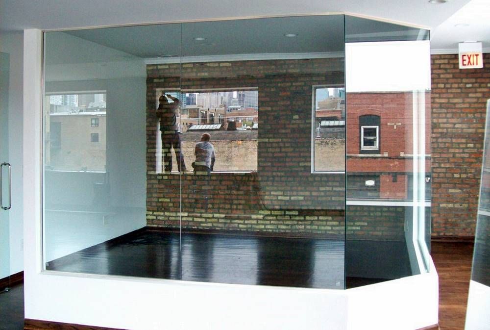 An empty room with a brick wall and a glass wall