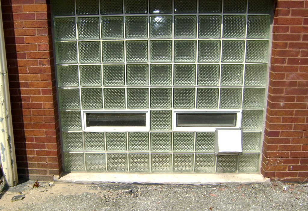 A brick wall with a window made of glass blocks