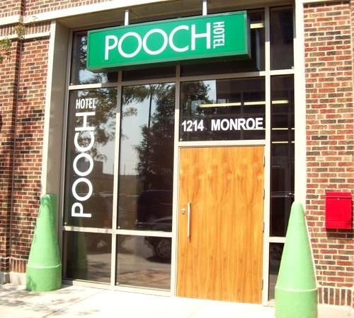 A brick building with a green sign that says pooch hotel