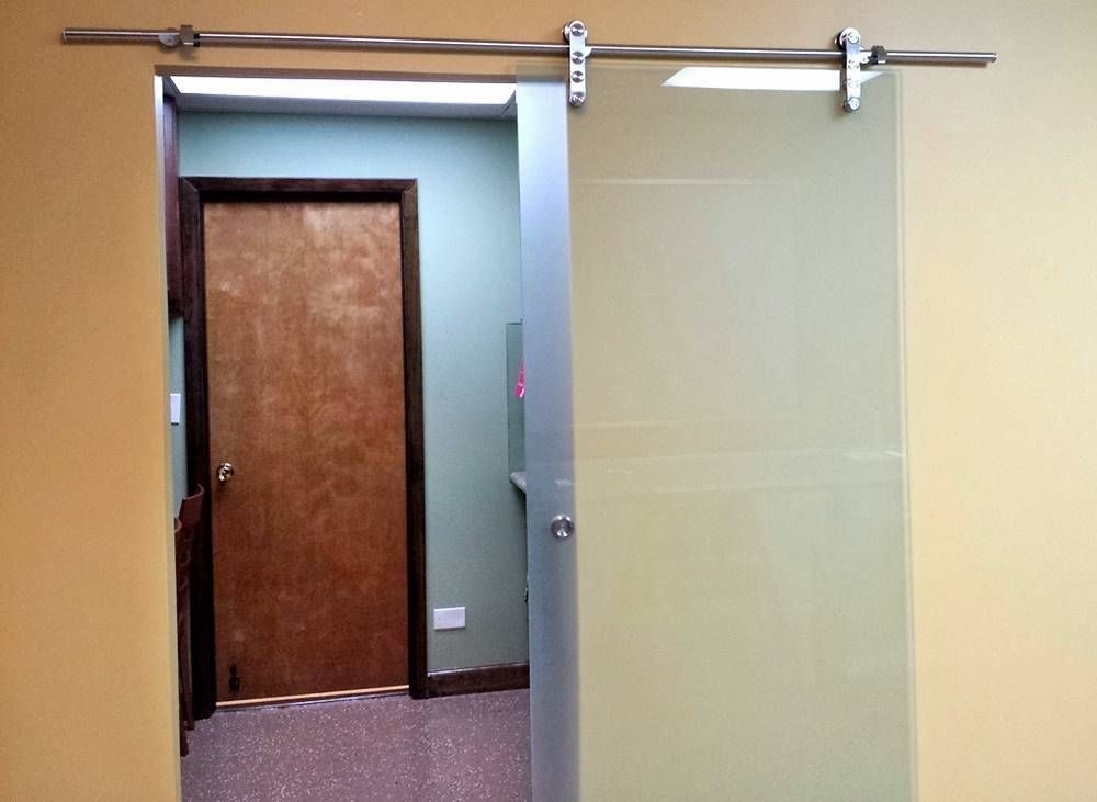 A sliding glass door in a room with a wooden door