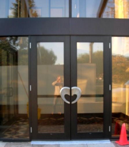 A black door with a heart shaped handle