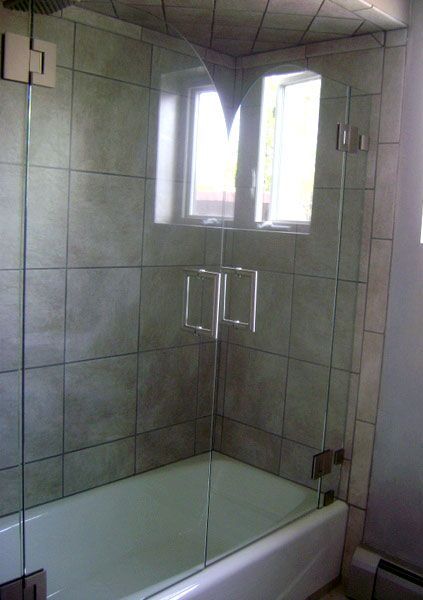 A bathroom with a bathtub and a glass shower door