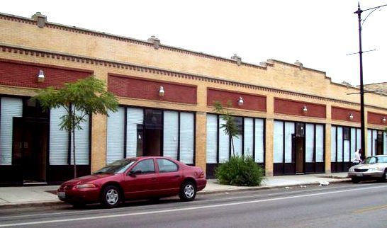 A red car is parked in front of a building