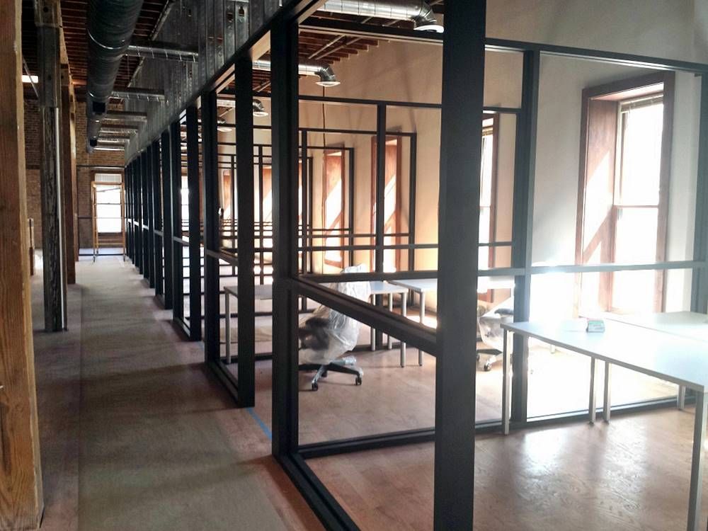A long hallway with tables and chairs in a building under construction.