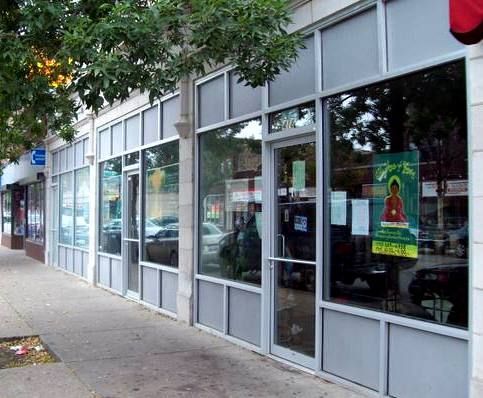 A store front with a green sign that says ' jesus loves you ' on it