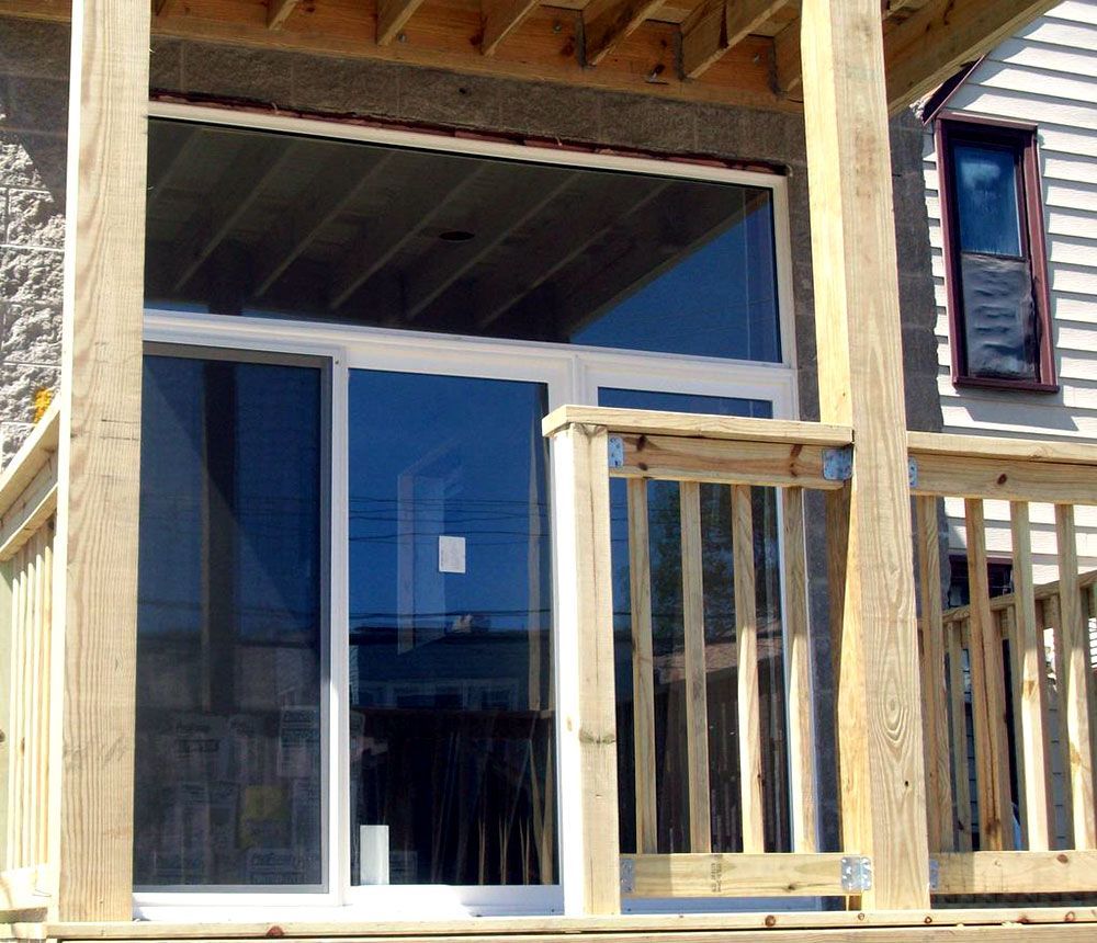 A wooden porch with a sliding glass door