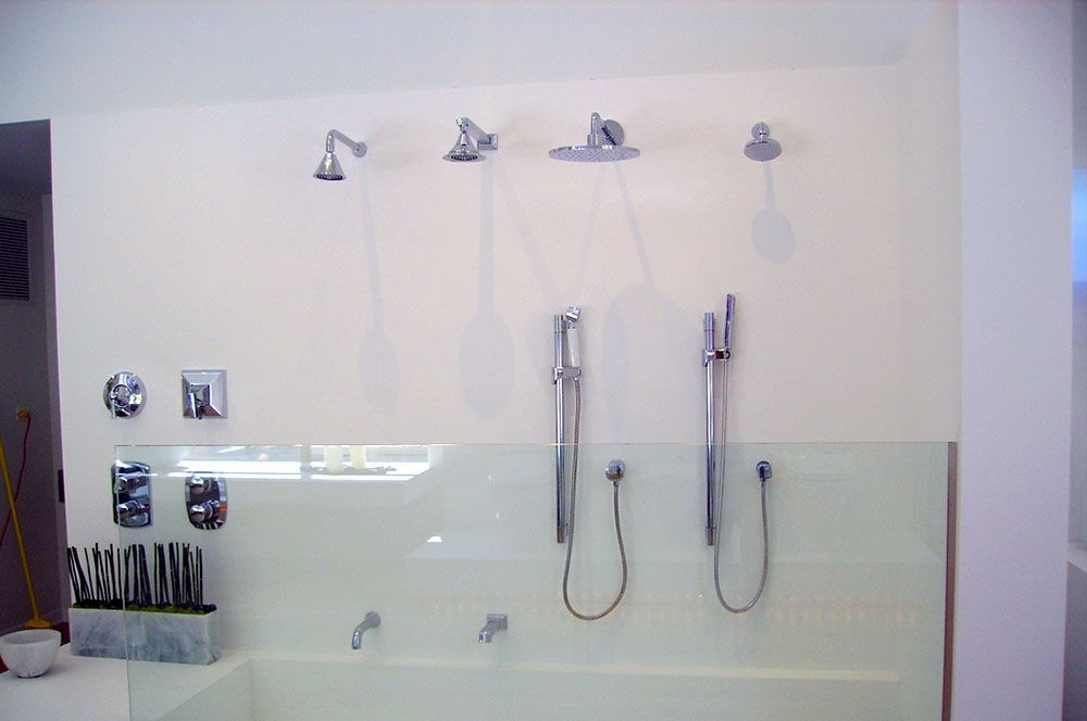 A bathroom with three showers and a bathtub