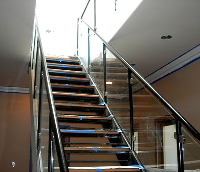 A staircase with a glass railing and wooden steps