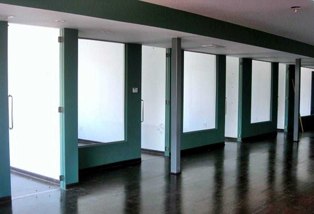 An empty room with green walls and white pillars