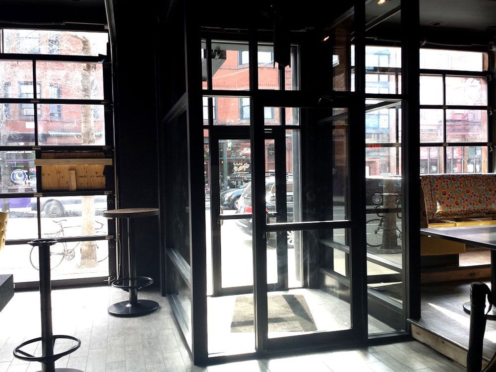 A restaurant with a lot of windows and tables and chairs.