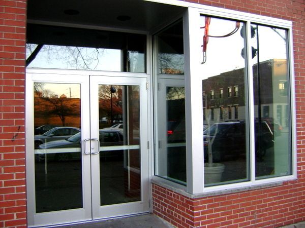 A brick building has a large window with the letter p on it