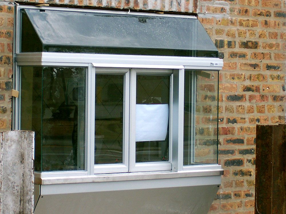 A window on a brick building with a white sign on it