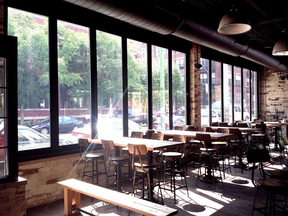 A restaurant with lots of windows and tables and chairs