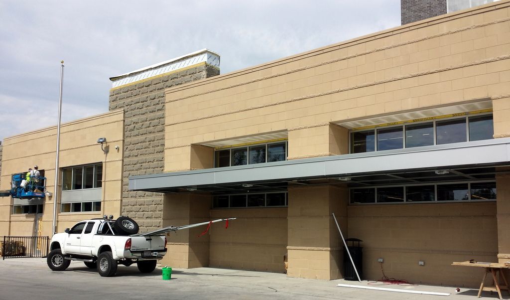 A white truck is parked in front of a large building