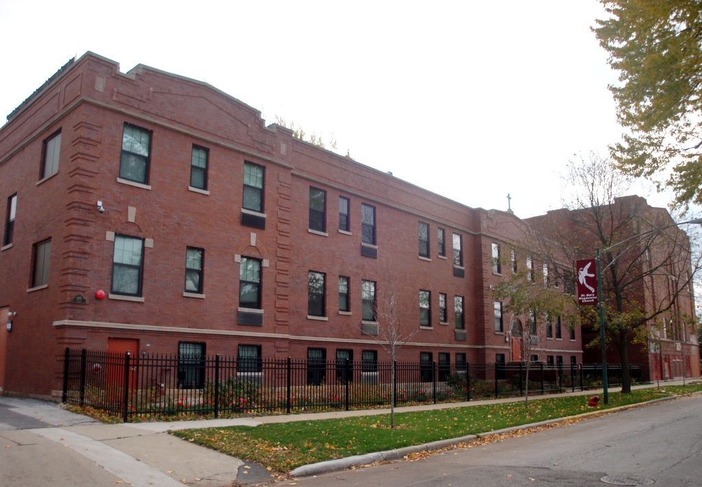 A large brick building with a red arrow pointing to the right