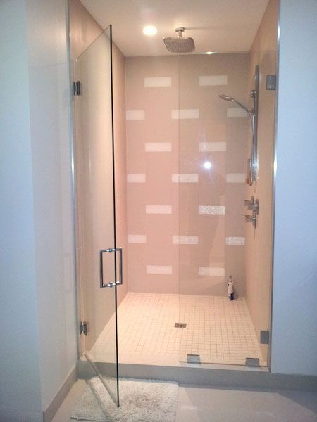 A bathroom with a walk in shower with a glass door