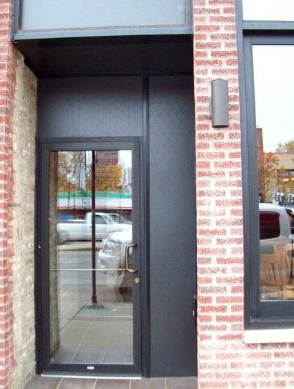 A brick building with a black door and a window
