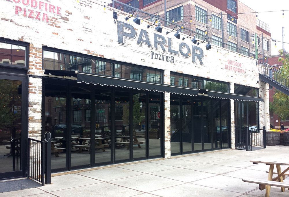 A large building with a lot of windows and a sign that says parlor pizza