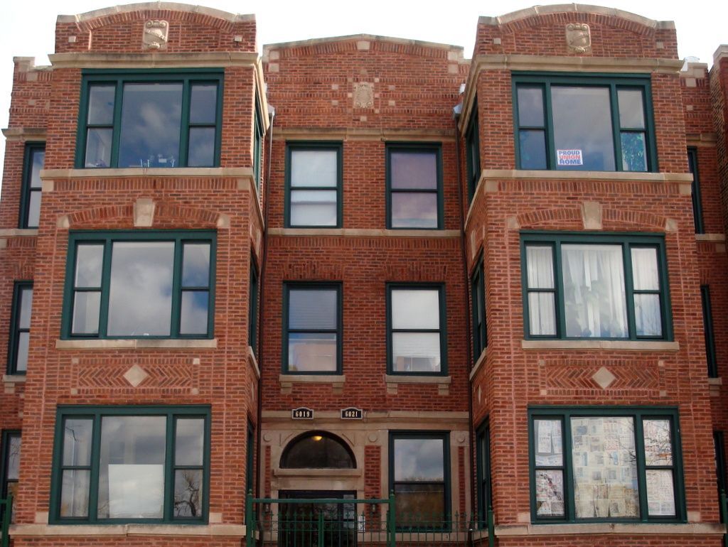 A large brick building with lots of windows and a sign that says for sale