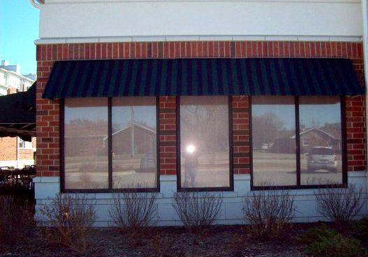 A brick building with a black awning over the windows