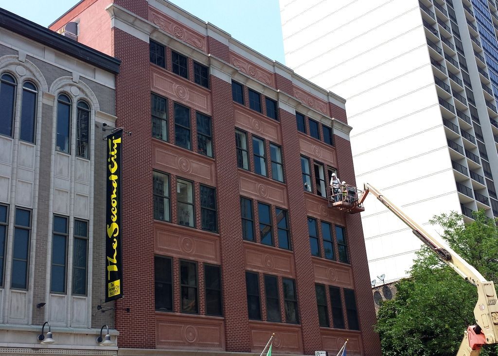 A brick building with a yellow sign that says the second floor