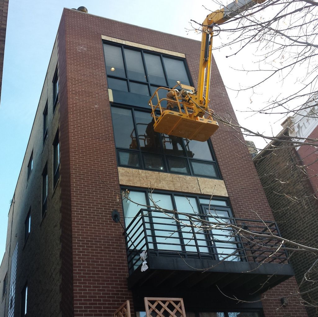 A large brick building with a yellow crane on top of it