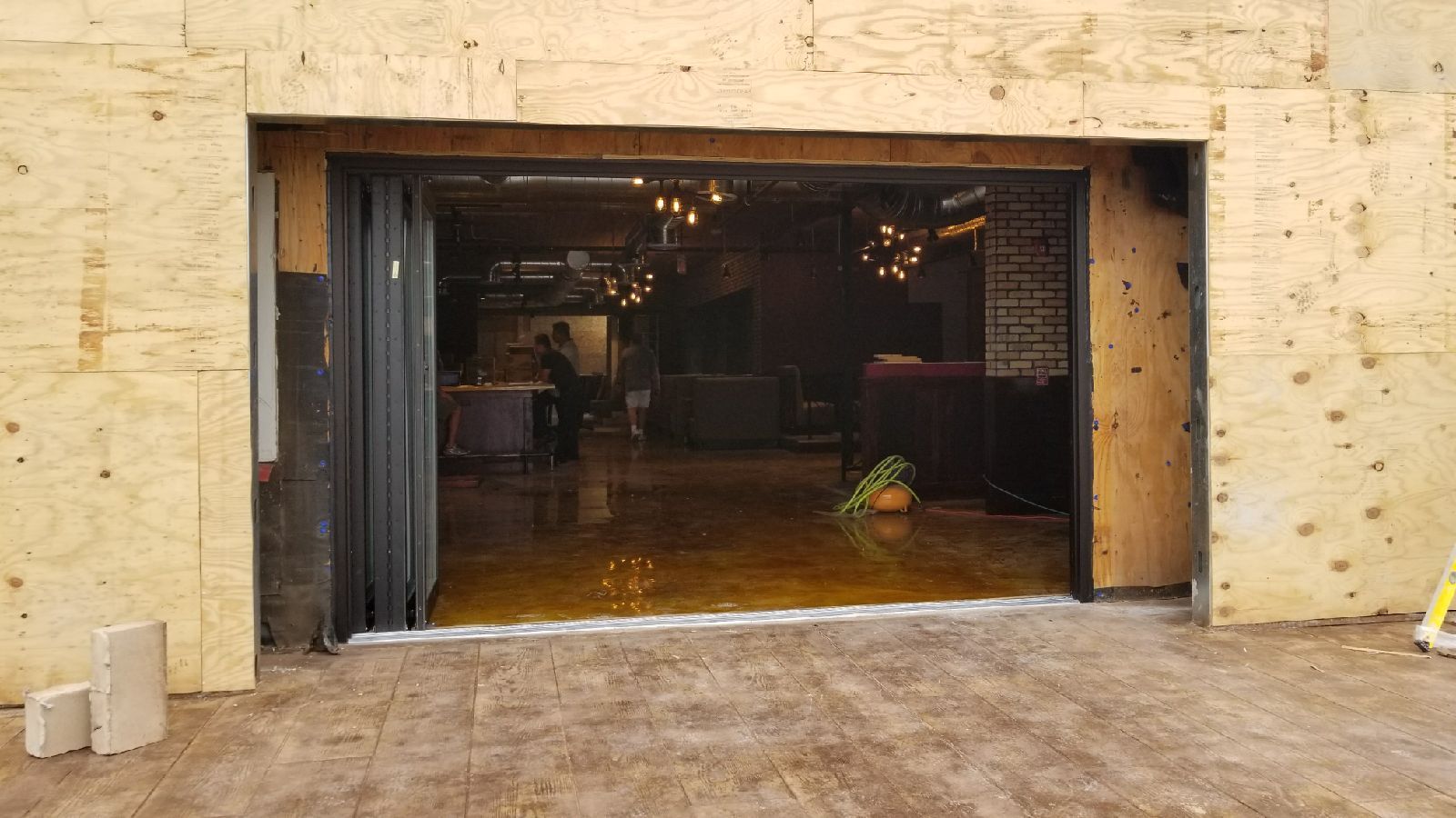 A garage door is open to a room in a building under construction.