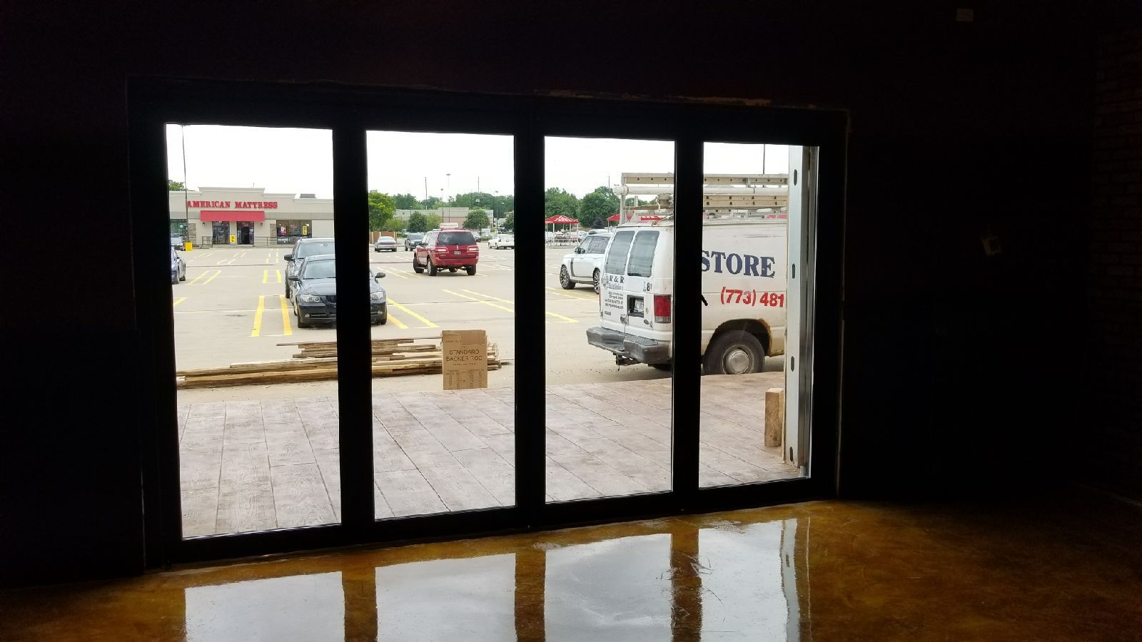 A room with a lot of windows and a truck in the background.