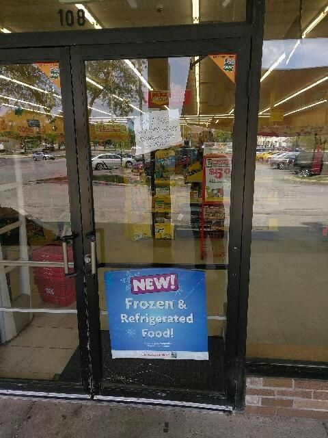 A store front with a sign that says new frozen and refrigerated food