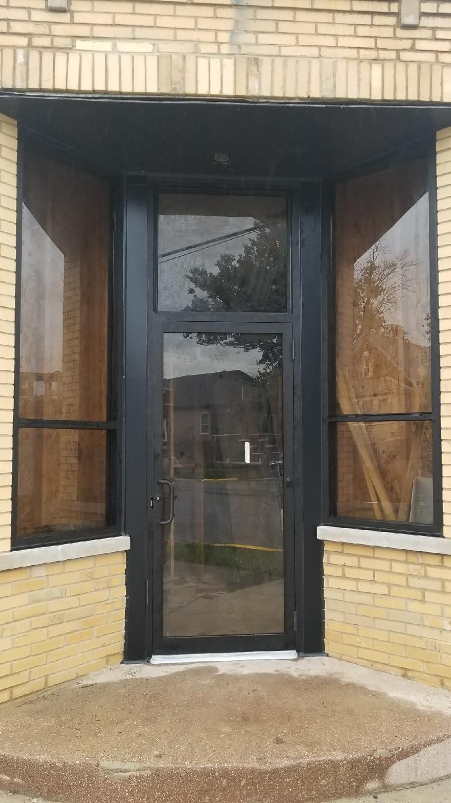 A brick building with a black door and windows.