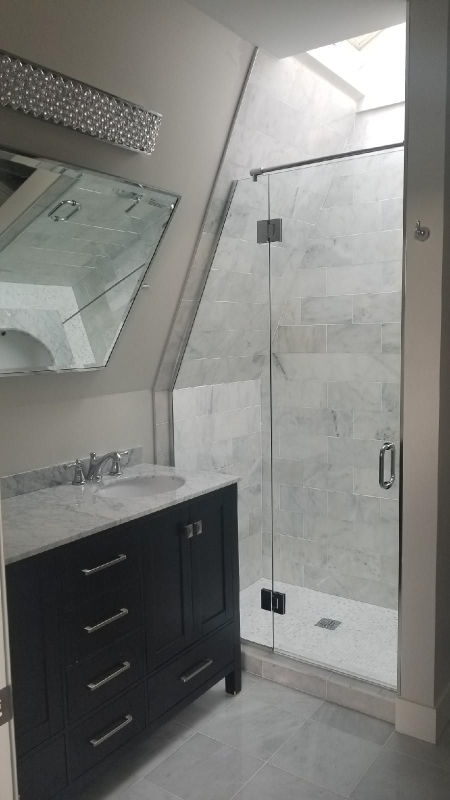 A bathroom with a sink , mirror and walk in shower.