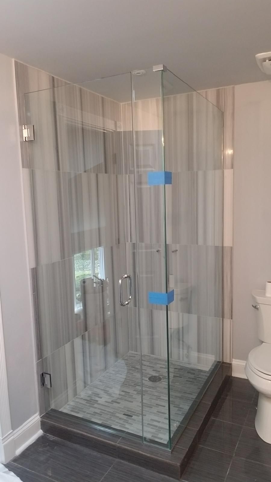 A bathroom with a walk in shower and a toilet.