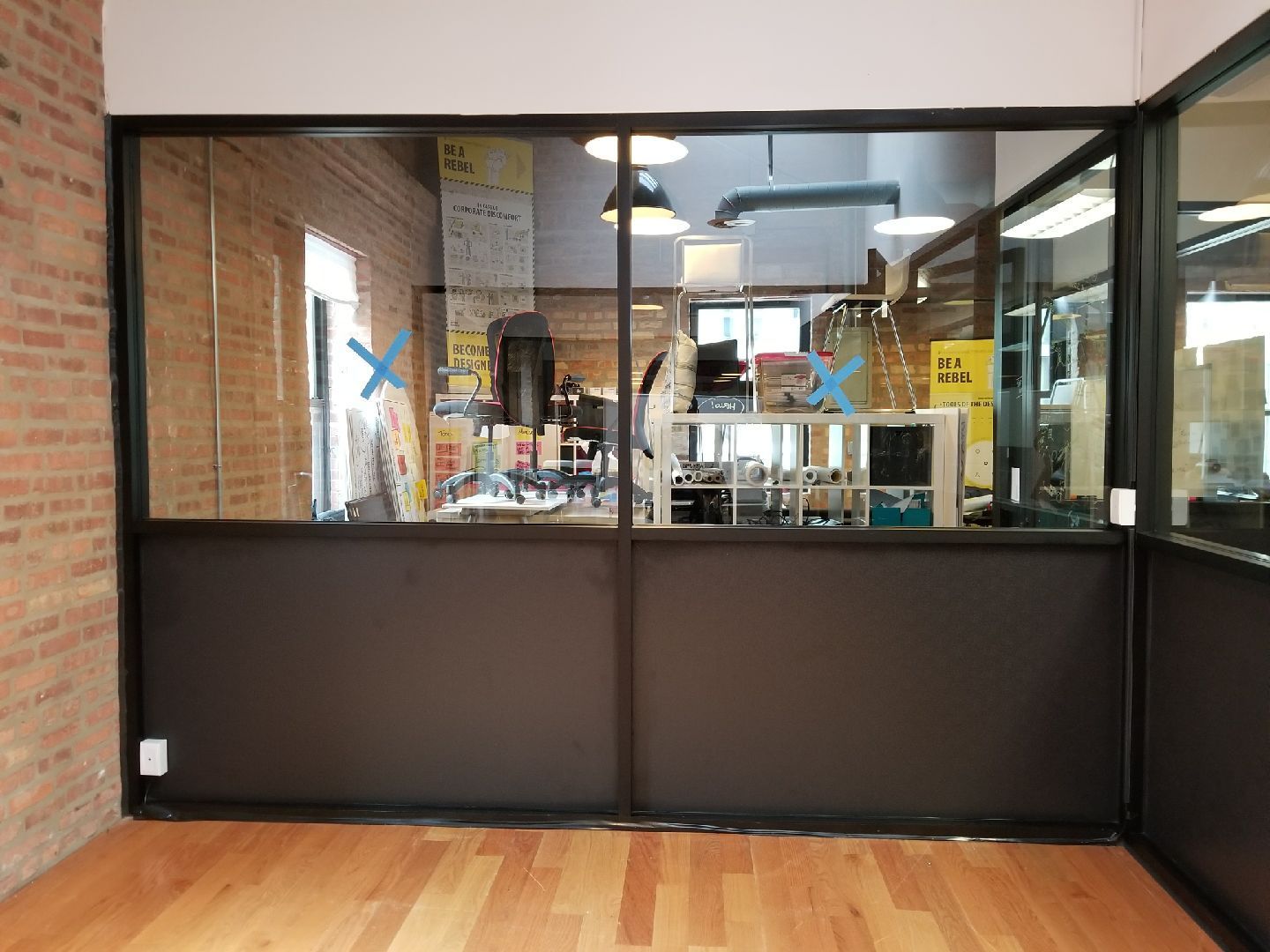 A room with a large window and a wooden floor.