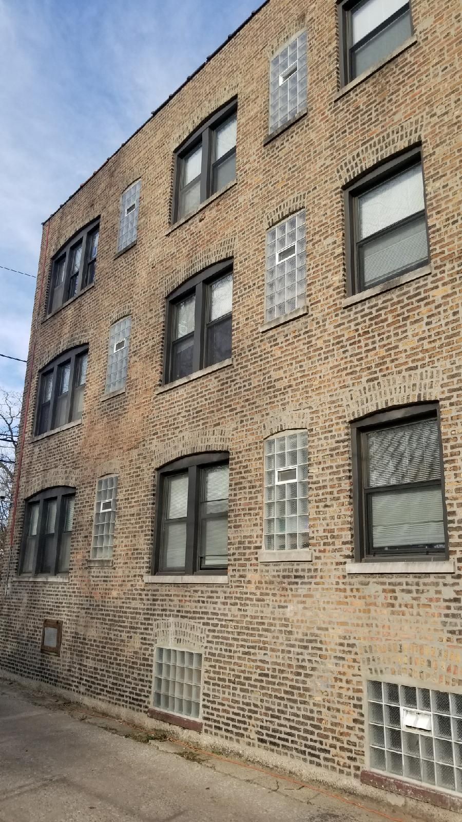 A large brick building with a lot of windows on a sunny day.