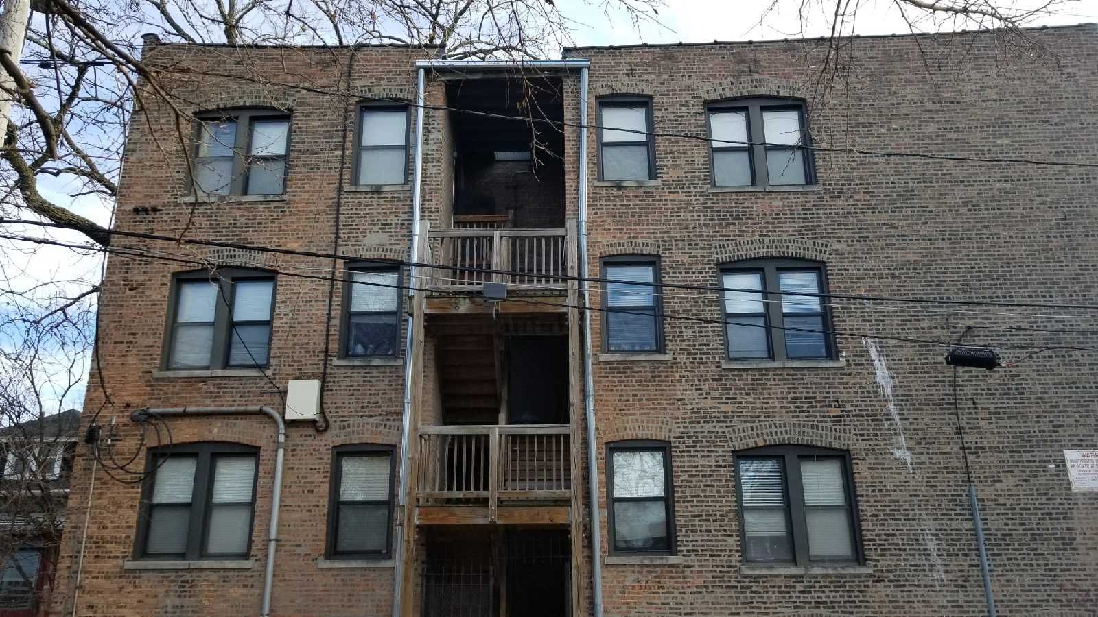 A large brick building with many windows and stairs.