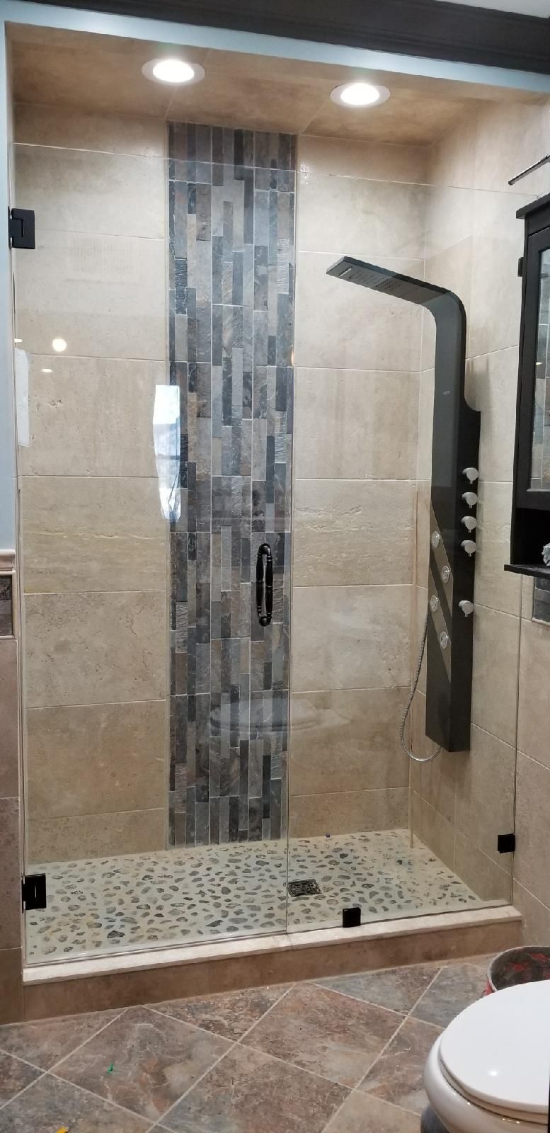 A bathroom with a walk in shower and a toilet.