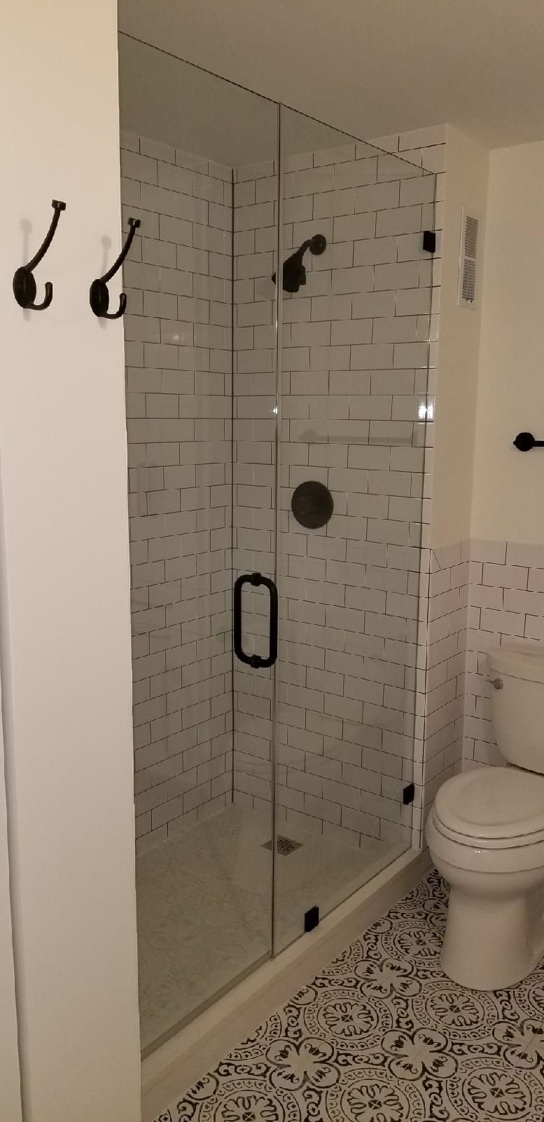A bathroom with a toilet and a shower with a glass door.