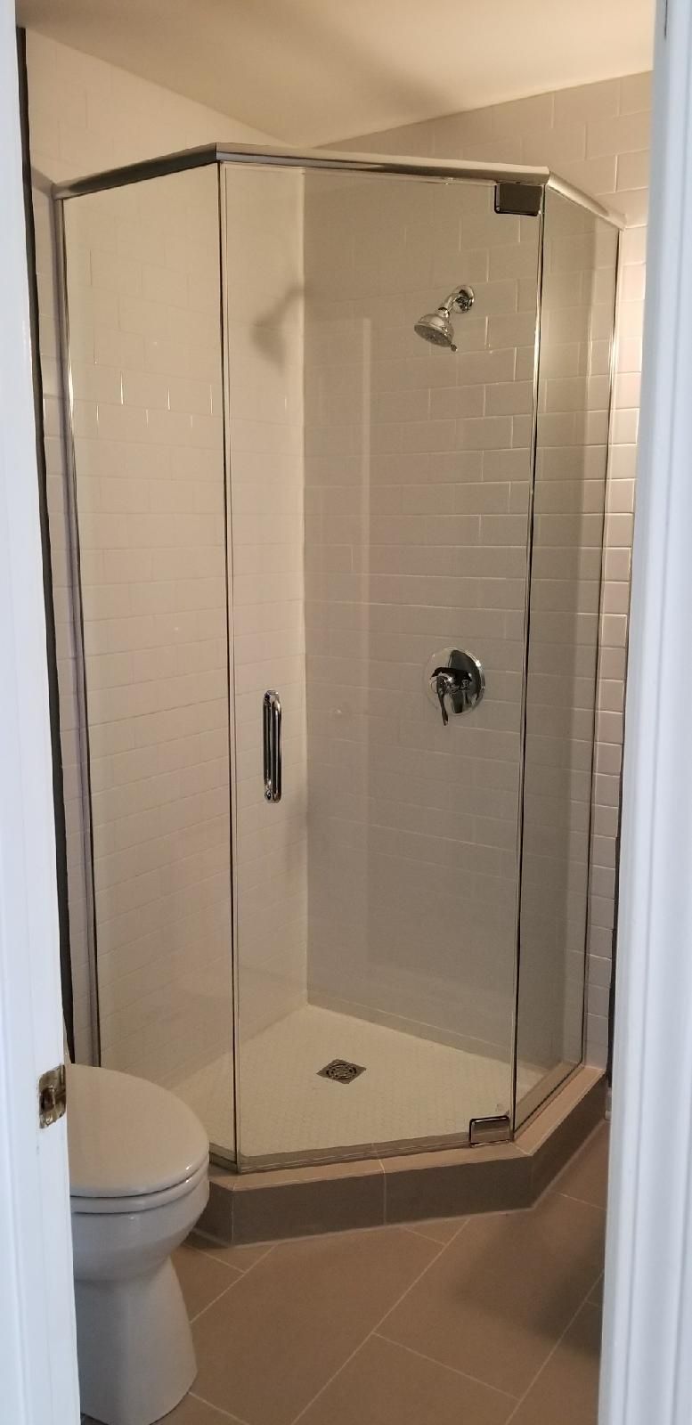 A bathroom with a toilet and a shower stall.