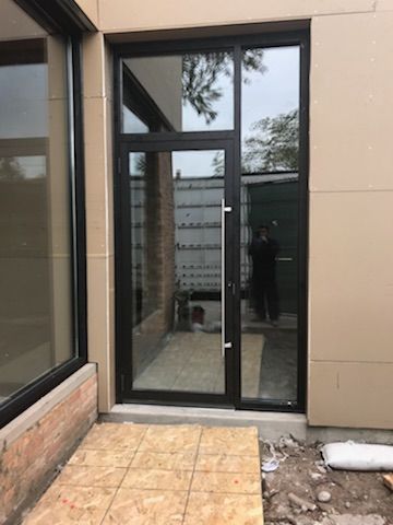 A large glass door is sitting on the side of a building.