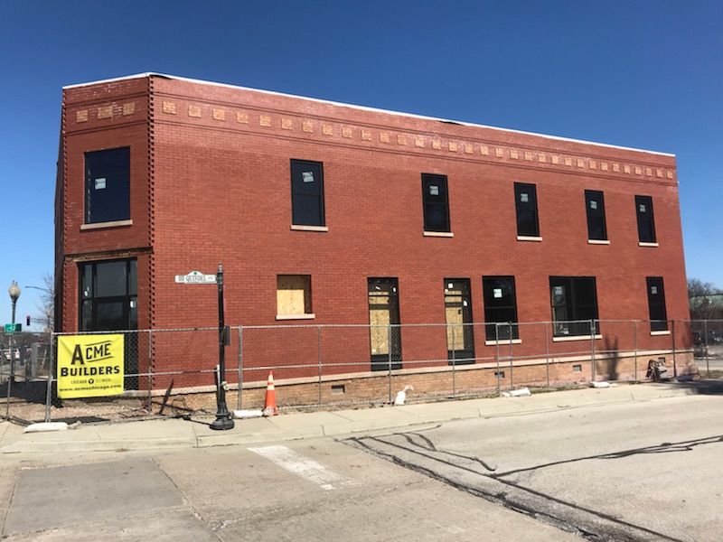 A large brick building with a yellow sign that says apl builders