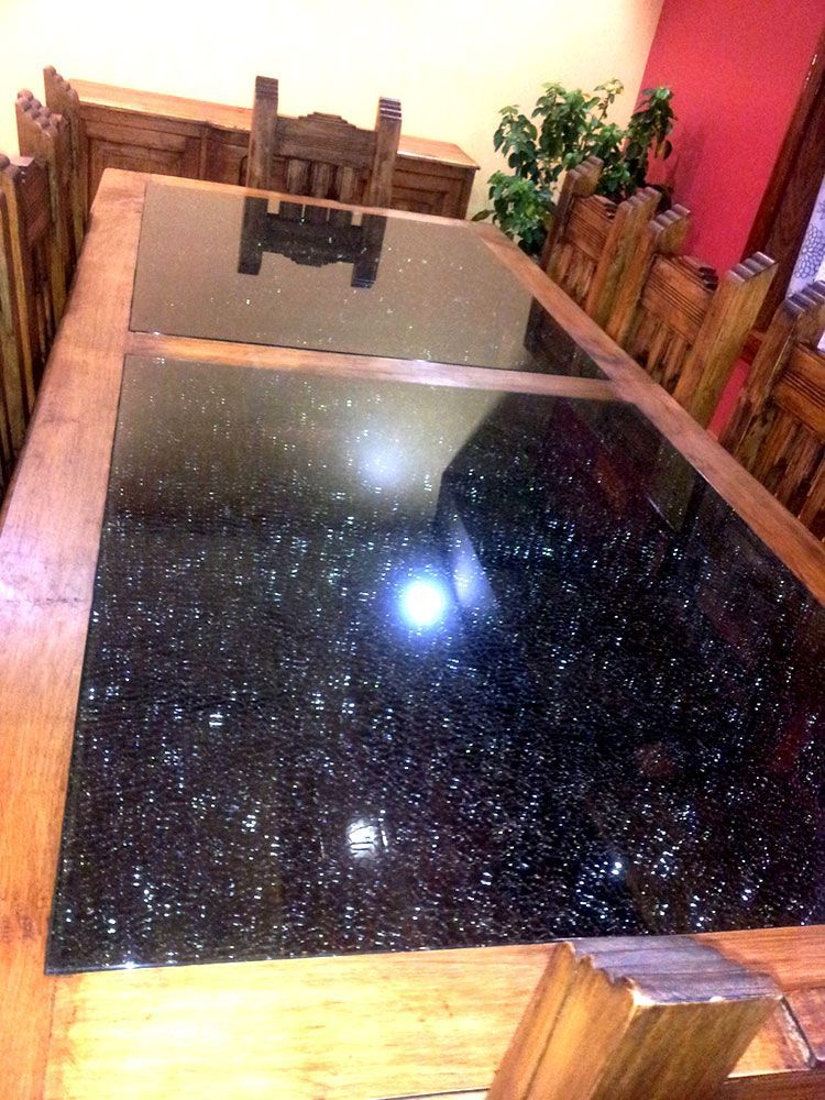 A dining room table with a black granite top and wooden chairs