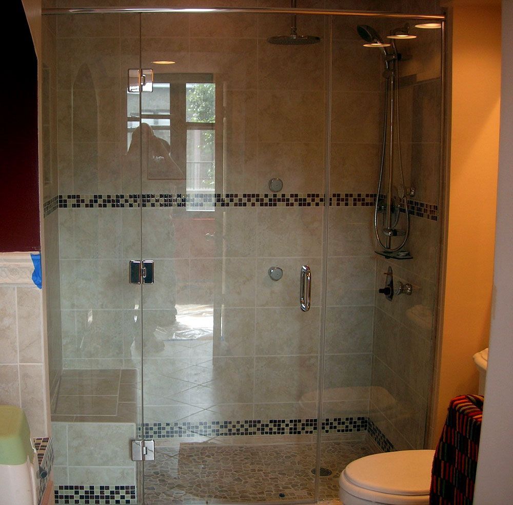 A bathroom with a glass shower door and a toilet