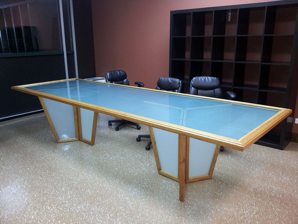 A conference room with a long glass table and chairs