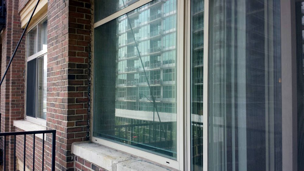 A brick building with a large window and a sliding glass door.
