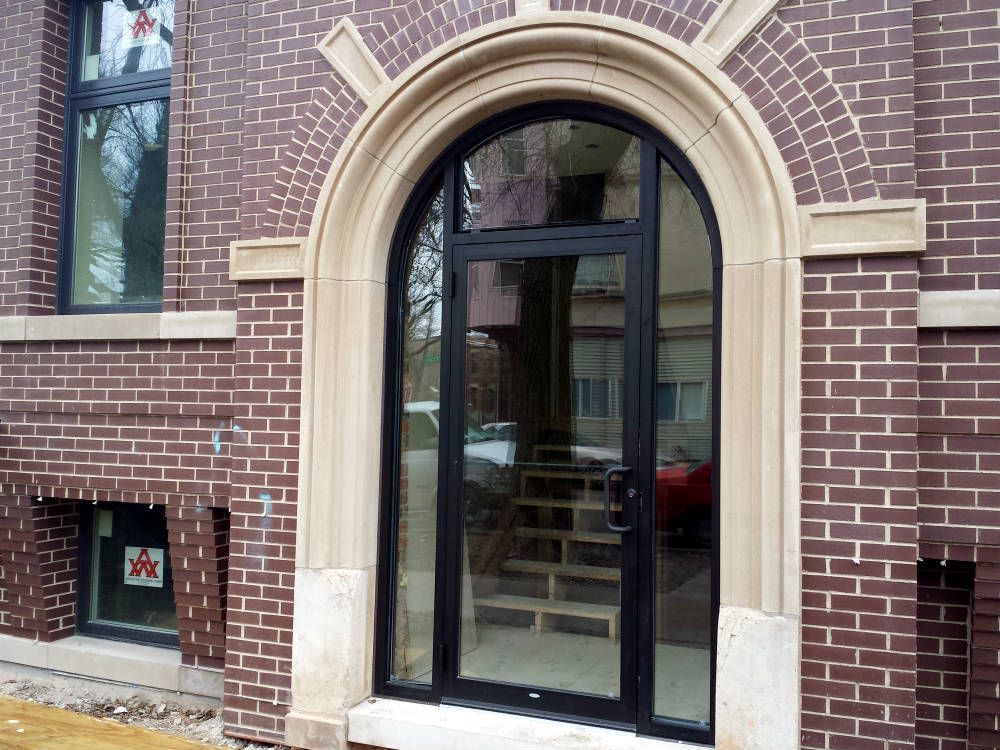 A brick building with a black door and arched window